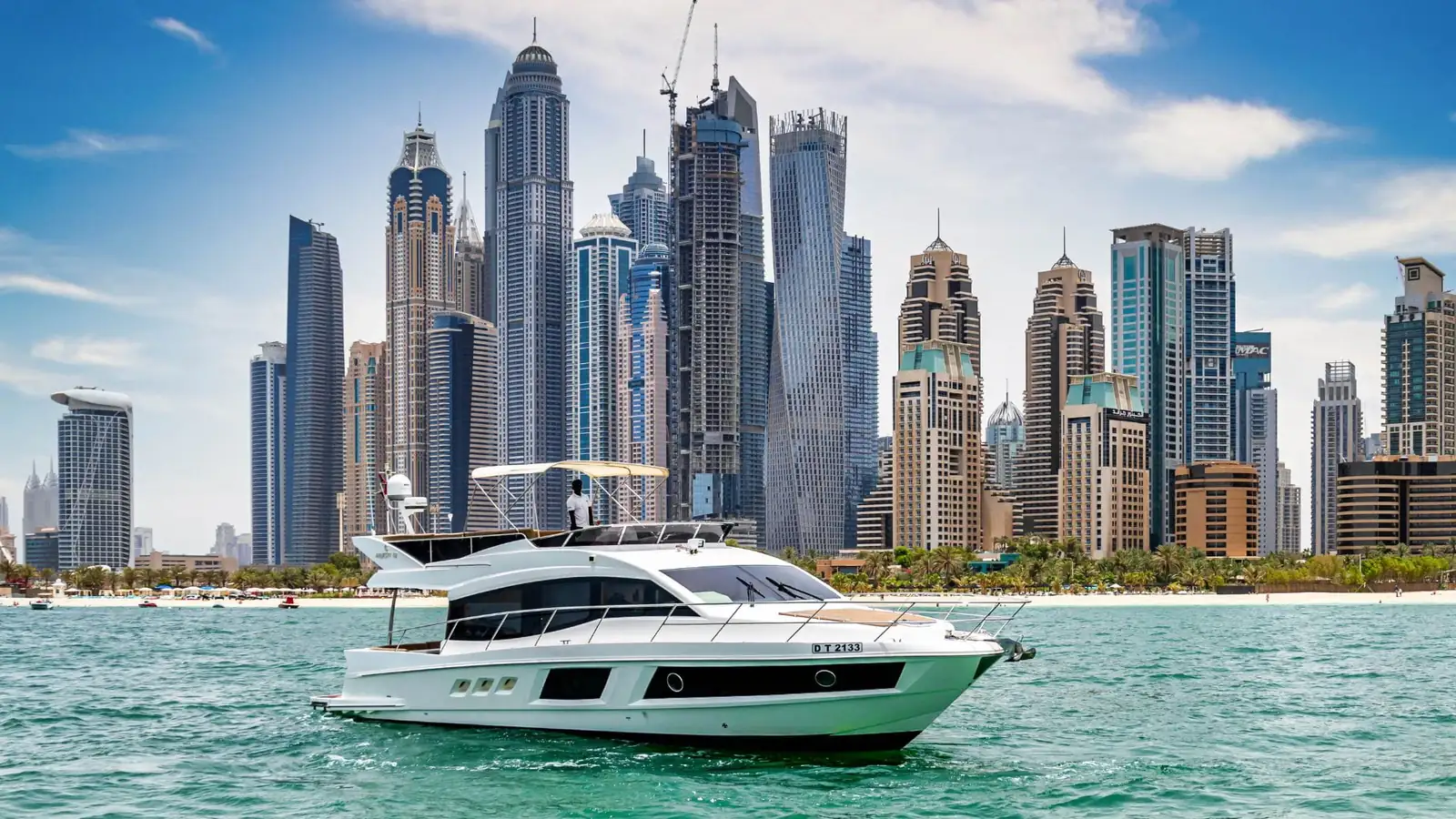 Un yacht à moteur blanc amarré dans une marina de Dubaï par jour de vent, en attendant une mer plus calme