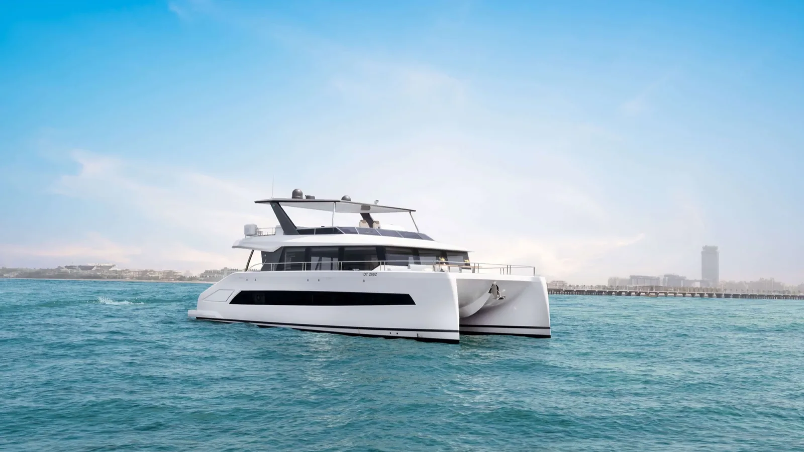 Morning on the beach next to Dubai Harbour with a yacht cruising offshore